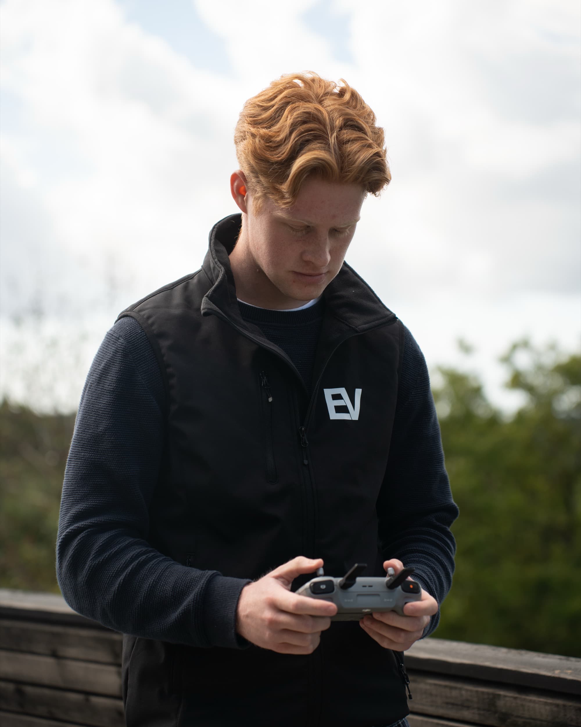 Petter Enger ser ned på dronekontrolleren mens han flyr.
